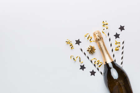 bottle of champagne with glasses and colorful confetti on colored background. top view flay lay.の写真素材