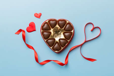 Delicious chocolate pralines in red box for Valentine's Day. Heart shaped box of chocolates top view with copy space.の写真素材