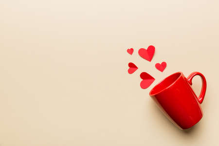 red cup on colored background, splashes of red little hearts, top view with copy space.の写真素材