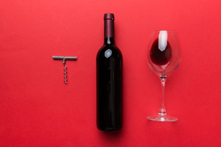 Flat lay composition with corkscrew, bottle of wine and elegant glass on colored table. Flat lay, top view wth copy space.の写真素材
