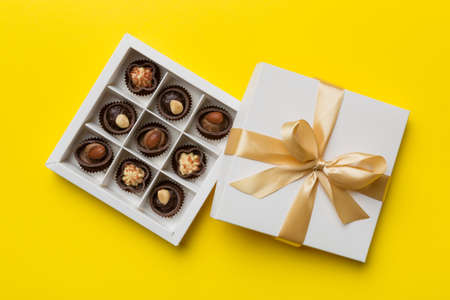 White box with chocolates candies and golden tape. top view with copy space.