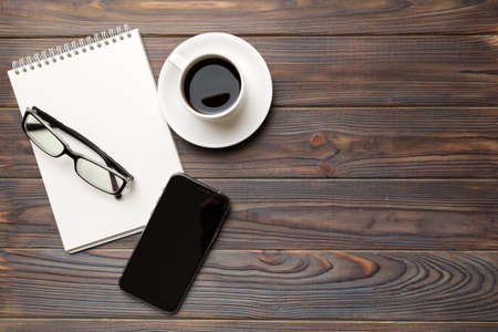Modern office desk table with notebook, smartphone and other supplies with cup of coffee. Blank...