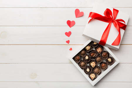 Delicious chocolate pralines in red box for Valentine's Day. Heart shaped box of chocolates top view with copy space.の写真素材