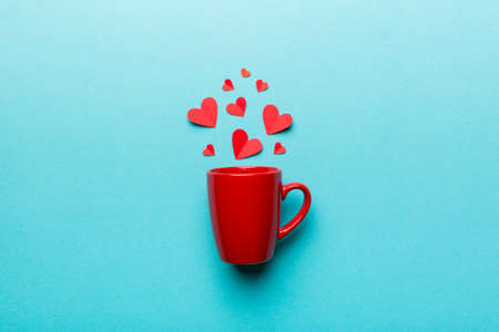 red cup on colored background, splashes of red little hearts, top view with copy space.の写真素材