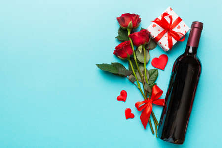 Valentine's day composition with red wine, rose flower and gift box on table. Top view, flat lay. Holiday concept.の写真素材