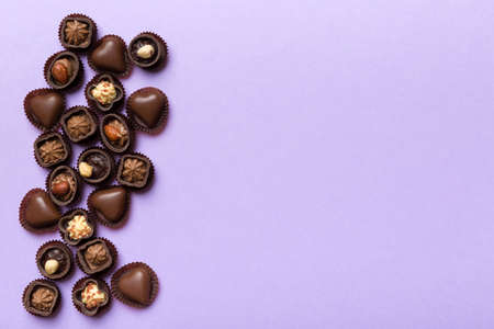 Different kinds of chocolates on colored table close-up. Top View and Flat Lay with copy space.