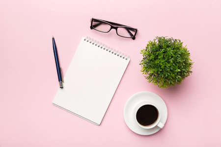 Modern office desk table with notebook and other supplies with cup of coffee. Blank notebook page for you design. Top view, flat lay.の写真素材