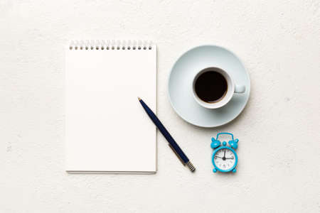 Modern office desk table with notebook and other supplies with cup of coffee. Blank notebook page for you design. Top view, flat lay.の写真素材