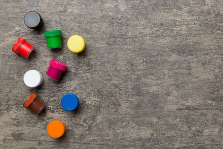 jars with gouache of different colors on Colored background. hobby painting. Top view with empty space. workplace for creativity. home teaching concept drawing.の写真素材