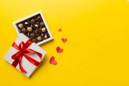 Delicious chocolate pralines in red box for Valentine's Day. Heart shaped box of chocolates top view with copy space.の写真素材