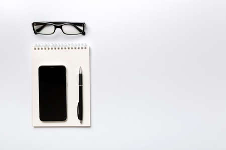 Smartphone with a notebook on a light Color background. top view.の写真素材