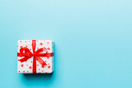 Valentine day composition: red gift box with bow and heart. Christmas present. View from above. Space for text. Holday greeting card.の写真素材