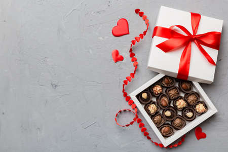 Delicious chocolate pralines in red box for Valentine's Day. Heart shaped box of chocolates top view...