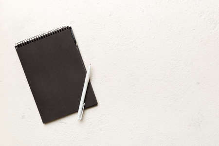 school notebook on a colored background, spiral black notepad on a table Top view.
