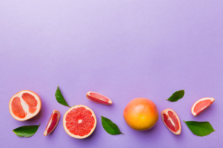 fresh Fruit grapefruit with Juicy grapefruit slices on colored background. top view. copyspace. creative summer concept. Half of citrus in minimal flat lay with copy space.の写真素材