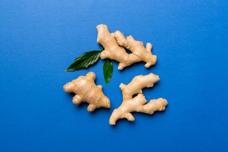 Finely dry Ginger powder in bowl with green leaves isolated on colored background. top view flat lay.の写真素材