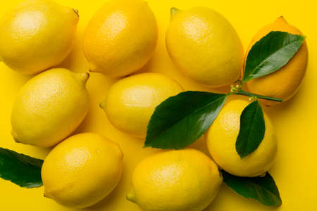 Many fresh ripe lemons as colored background, top view. Elegant background of lemon and lemon slices Top view flat lay.の写真素材