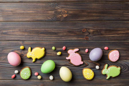 holiday preparation Multi colors Easter eggs with cookies on colored background . Pastel color...