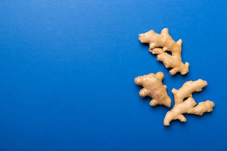 Finely dry Ginger powder in bowl with green leaves isolated on colored background. top view flat lay.の写真素材