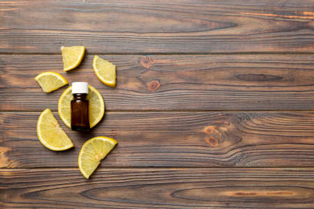 Bottles with lemon fruit essential oil on wooden background. alternative medicine top view with copy space.の写真素材