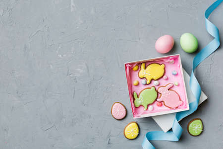 Colorful easter cookies in basket with Multi colors Easter eggs on colored background . Pastel color Easter eggs. holiday concept with copy space.の写真素材