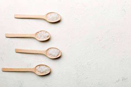 salt on wooden spoon on wood background. Spoons with different salt.の写真素材