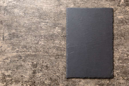 top view of empty black slate plate on cement background. Empty space for your design.の写真素材
