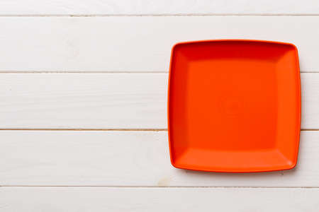 Top view of empty square plate on wooden background. Empty space for your design.の写真素材
