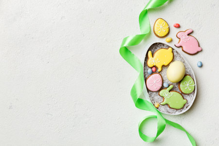 Colorful easter cookies in basket with Multi colors Easter eggs on colored background . Pastel color...