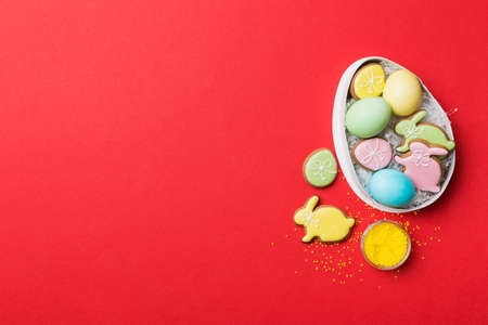 Colorful easter cookies in basket with Multi colors Easter eggs on colored background . Pastel color...