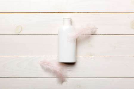 Set of skin care serums on pink pastel background with ostrich feathers. Spa cosmetic product, cream...