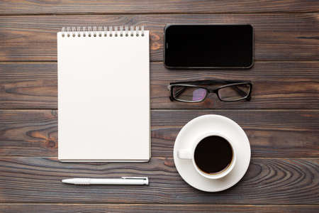 Modern office desk table with notebook, smartphone and other supplies with cup of coffee. Blank...