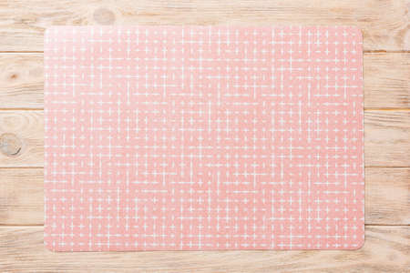 Top view of red tablecloth for food on wooden background. Empty space for your design.