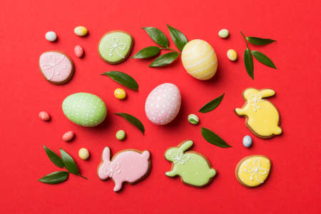 holiday preparation Multi colors Easter eggs with cookies on colored background . Pastel color...