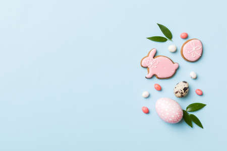 holiday preparation Multi colors Easter eggs with cookies on colored background . Pastel color...