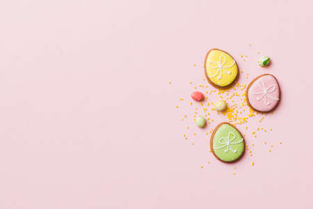 holiday preparation Multi colors Easter eggs with cookies on colored background . Pastel color...