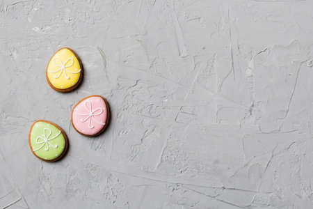 holiday preparation Multi colors Easter eggs with cookies on colored background . Pastel color...