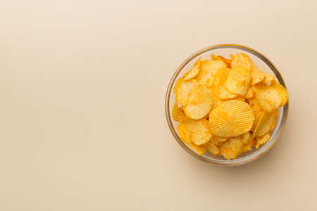 Potato chips on bowl isolated on colored background. Delicious crispy potato chips in bowl. Space for text. top view.の写真素材