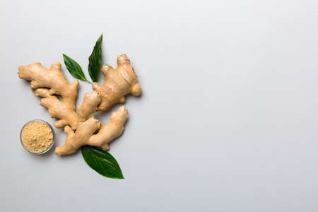 Finely dry Ginger powder in bowl with green leaves isolated on colored background. top view flat lay.の写真素材