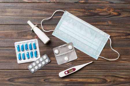 Protective face masks or surgical masks, medicine pills and thermometer on table background. coronavirus disease. Corona virus concept. Space for text.の写真素材
