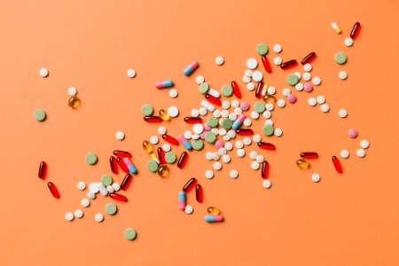 assorted pills and tablets top border over colored background. Many different pills and space for text on colorful background, top view.の写真素材
