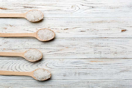 salt on wooden spoon on wood background. Spoons with different salt.の写真素材