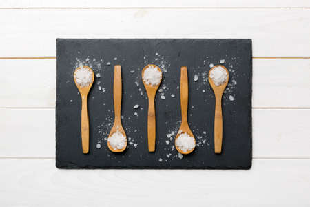 salt on wooden spoon on wood background. Spoons with different salt.の写真素材