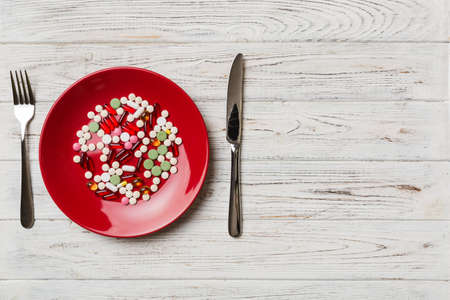 Many different weight loss pills and supplements as food on round plate. Pills served as a healthy meal. Drugs, pharmacy, medicine or medical healthycare concept.の写真素材
