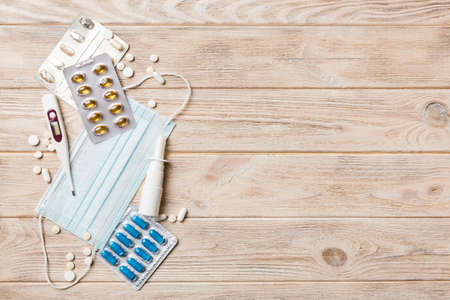 Protective face masks or surgical masks, medicine pills and thermometer on table background. coronavirus disease. Corona virus concept. Space for text.の写真素材