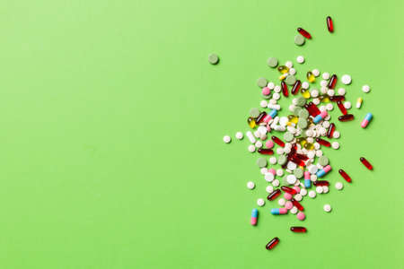 assorted pills and tablets top border over colored background. Many different pills and space for...
