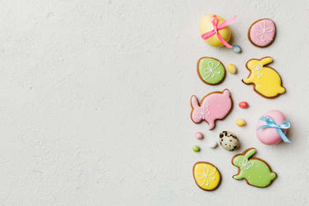 holiday preparation Multi colors Easter eggs with cookies on colored background . Pastel color...