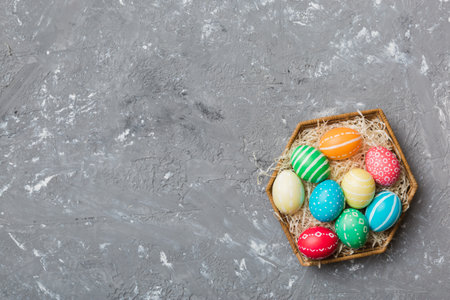 Multi colors Easter eggs in the woven basket on colored background . Pastel color Easter eggs....