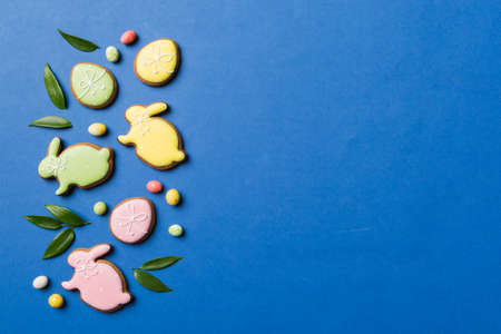 holiday preparation Multi colors Easter eggs with cookies on colored background . Pastel color...