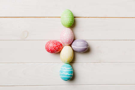 holiday preparation Multi colors Easter eggs on colored background, cross show the religious and secular side of Easter. Pastel color Easter eggs. holiday concept with copy space.の写真素材